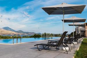 里科索翁Phaedra Suites的一组椅子和遮阳伞,位于游泳池旁