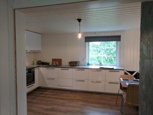 SkarsvågNorth Cape family lodge的厨房配有白色橱柜和窗户。