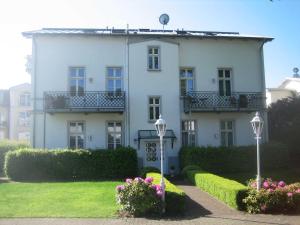 赛巴特班森Villa Baroni BF nur 200m vom Ostseestrand entfernt的前面有鲜花的大白色房子