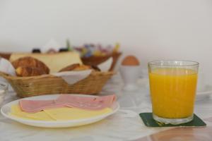 伊利索斯特力安塔酒店公寓的一杯橙汁,放在一盘面包旁边