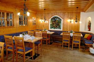 贝希特斯加登科隆普林兹酒店的餐厅拥有木墙和木桌及椅子