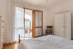 马戈马达斯Casa Bea Bosa/Magomadas的一间卧室设有一张床和一个大窗户