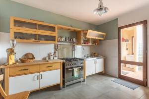 马戈马达斯Casa Bea Bosa/Magomadas的厨房配有白色橱柜和炉灶烤箱。
