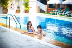 清迈皇后大酒店 - SHA Extra Plus的躺在游泳池里的男人和女人