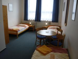 布拉格哈萨酒店的一间设有两张床和一张桌子及椅子的房间