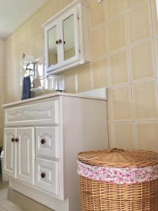 棕榈滩布巴里花园公寓的一间白色橱柜和篮子的浴室
