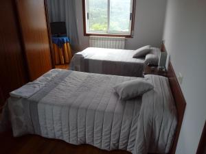 欧德鲁佐Apartamento Cefas的一间卧室设有两张床和窗户。
