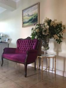 奥克宁卡Villa Spełnione Marzenia的紫色的长沙发和带花瓶的桌子