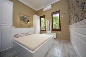 萨拉热窝Best of Bascarsija apartments的卧室配有白色的床和镜子