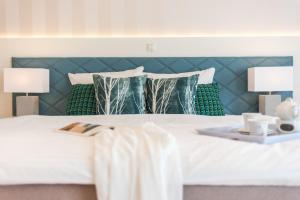 普雷罗Apartmenthaus Am Park的卧室配有带绿色枕头的白色床