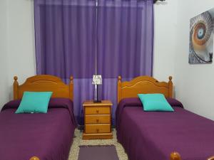 加拉奇科Atico con Vistas al Mar, Garachico的卧室内的两张床,配有紫色窗帘