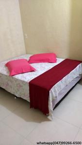 加斯帕Hostel Fariafaz的一间卧室配有两张带红色枕头的床