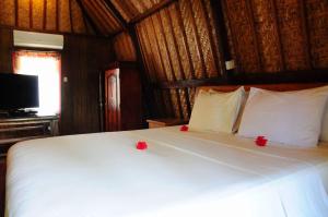吉利特拉旺安吉利福拉什协和酒店的卧室配有白色的床铺,上面有红色的鲜花