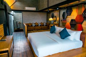 Ban Khanong Phra Tai维诺内斯特私人泳池别墅的一间卧室配有一张床和一张沙发