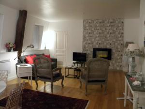 博讷Les chanceliers Duplex的客厅配有两把椅子和壁炉