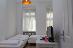 柏林Pandoras home的一间卧室设有两张床和一张桌子上的电视