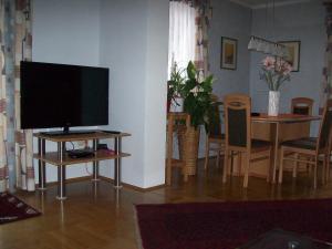 克拉根福Riedl Gästewohnung的一间带桌子电视的客厅和一间餐厅