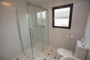 巴基GOLFVIEW 4的带淋浴和卫生间的浴室以及窗户。