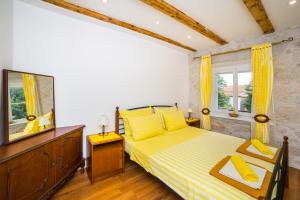 格拉达茨Apartments Stinice的一间卧室配有黄色的床和镜子