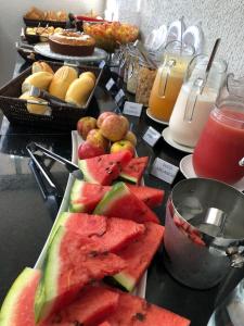 戈亚尼亚New Concept Hotel的一张桌子,上面放着一盘西瓜和其他水果