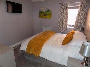 卡莱尔The Old Wool House Apartments的一间卧室配有一张黄色毯子床