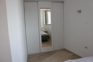 特斯特诺Apartments Platana的一间带镜子的卧室和一张位于客房内的床