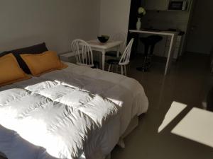 布兰卡港La Suitte的卧室配有白色的床和桌椅
