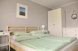 弗瓦迪斯瓦沃沃Pokoje Gościnne "Sowa"的白色卧室配有两张带绿色枕头的床