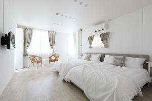大阪Bijou Suites Sorriso的白色卧室配有一张带白色床单的大床