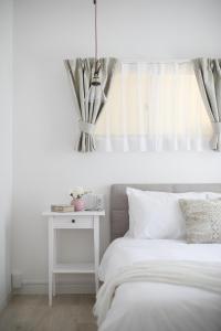 大阪Bijou Suites Sorriso的卧室配有白色的床和白色床头柜。