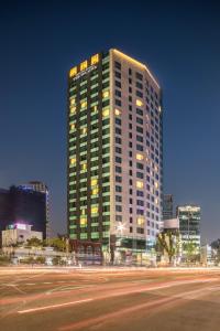 首尔喜普乐吉酒店首尔东大门的一座高大的建筑,前方有一条街道