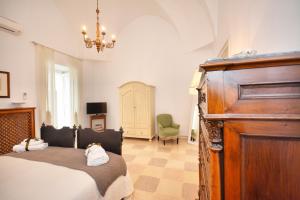 奥斯图尼Palazzo Rodio的一间卧室配有一张床和一个吊灯
