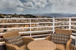 格拉纳达格拉纳达莱昂纳多酒店的阳台配有椅子,享有火车景色