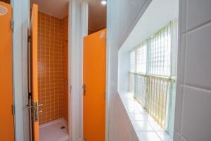 维塞乌VisHostel的带淋浴的橙色浴室和窗户。