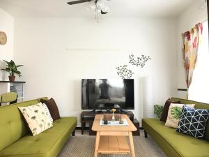 糸满EX Itoman Apartment 803的客厅配有两张绿色沙发和一张咖啡桌