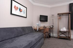 斯特利特Bear Inn, Somerset by Marston's Inns的一间卧室配有一张床、一张书桌和一台电视