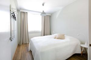 纳坦利Design Apartments Kristiina的白色的卧室设有白色的床和窗户。