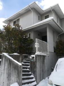 仙台Jukichi Owada Residence的前面的楼梯上积雪的房子