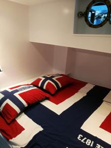 阿姆斯特丹houseboat Rose的一张带红色白色和蓝色棉被和镜子的床
