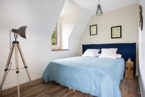 奥尔泰兹Le moulin des Sens - SPA-SAUNA的一间卧室配有蓝色的床和三角架