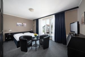 普鲁洪尼斯 潘普鲁洪尼斯图利酒店的酒店客房带一张床、一张桌子和椅子