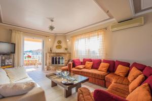 扎金索斯镇Zante View (4bedroom luxury home) Free Pickup的客厅配有红色的沙发和桌子