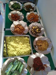 沙努尔乌玛巴古斯旅馆的盛满不同种类食物的碗的桌子