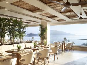 达西亚Ikos Dassia的一间带桌椅的海景餐厅