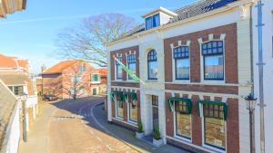 丽兹De Oude Pastorie Lisse的街道边有旗帜的建筑物