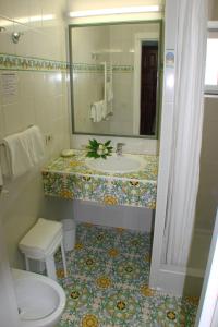 伊斯基亚Semiramis Hotel De Charme & Pools的一间带水槽和镜子的浴室