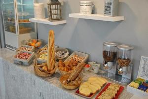 卢尔德Hôtel Angelic的自助餐,包括面包和其他食物在柜台上