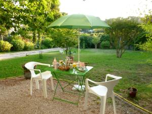 卡西斯Chez Mamouska的一张带绿伞的桌子和两把椅子