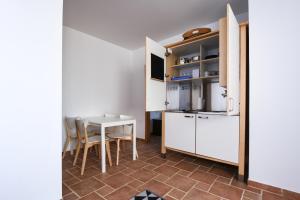 维拉·雷阿尔·德·桑托亚Pé na Areia - Guest House的厨房以及带桌椅的用餐室。