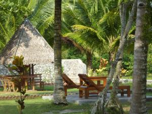 庞岸达兰爪哇泻湖住宿加早餐旅馆的公园,有两长椅和茅草屋
